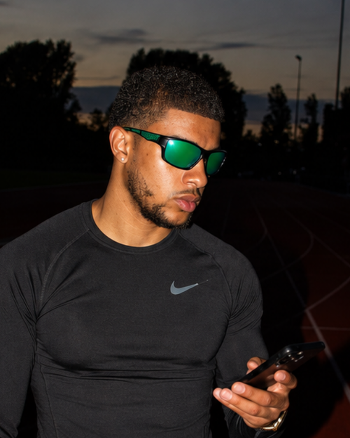 Athlete wearing the Bal Harbour Polarized Sunglasses at dusk on a running track